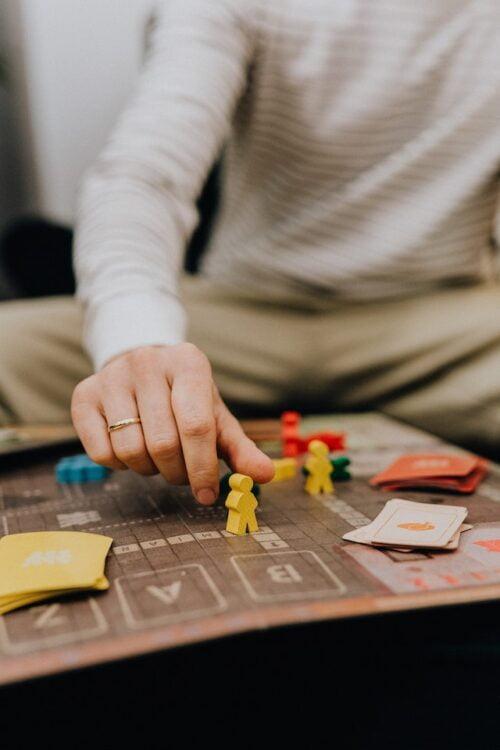 Board games vs card games, a man playing a board game including cards