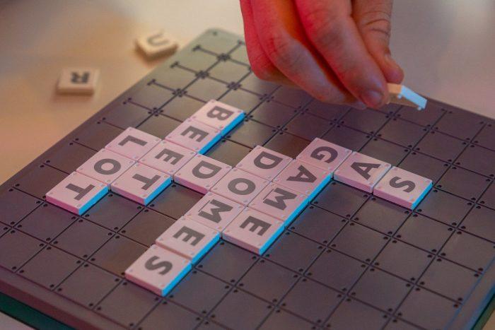 Popular Board Games for Adults Find the Most Fun Options, someone playing scrabble